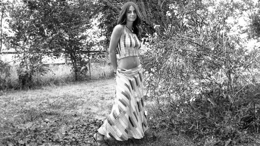 Boho long skirt girl in a garden, she is wearing a long skirt and a short top