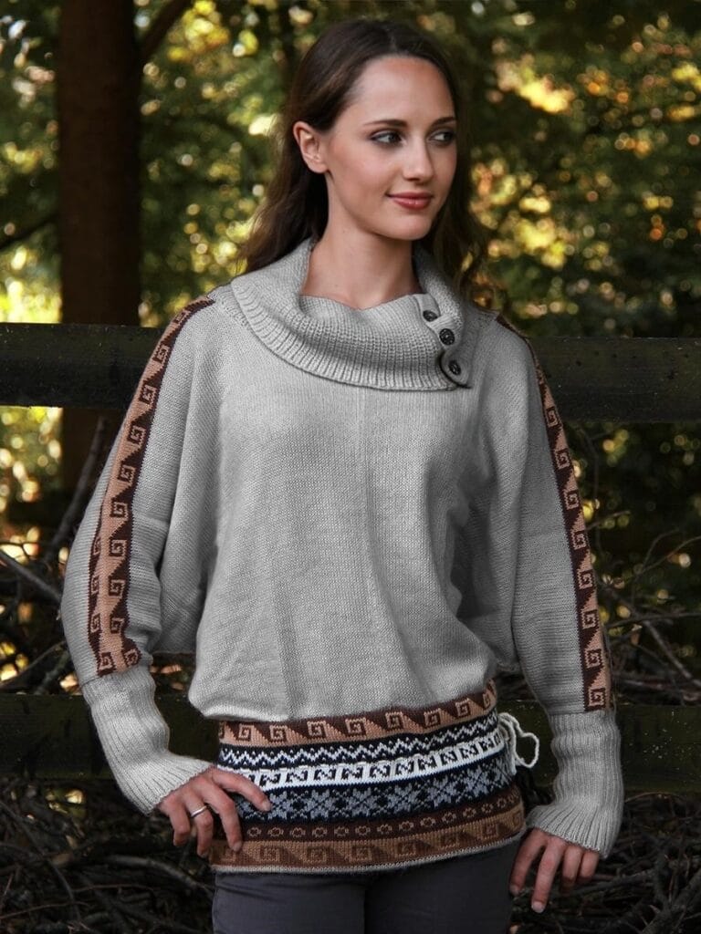 Woman wearing a batwing-sleeved alpaca jumper standing in a park in autumn